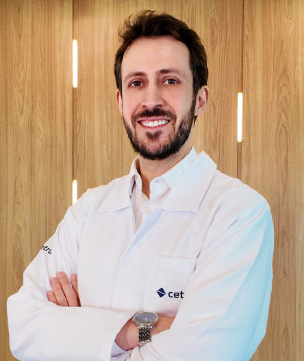 Dr. André Manso, médico especialista, vestindo jaleco branco do Cetrus e sorrindo com postura profissional.