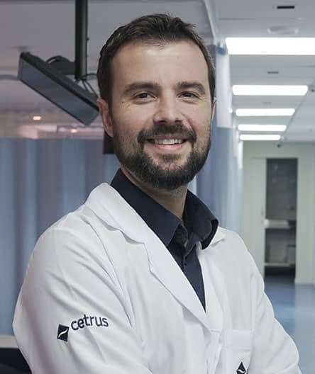 Dr. Estevão Vargas, coordenador dos cursos de ultrassonografia dermatológica, vestindo jaleco branco com o logotipo do Cetrus, sorrindo em um ambiente clínico.