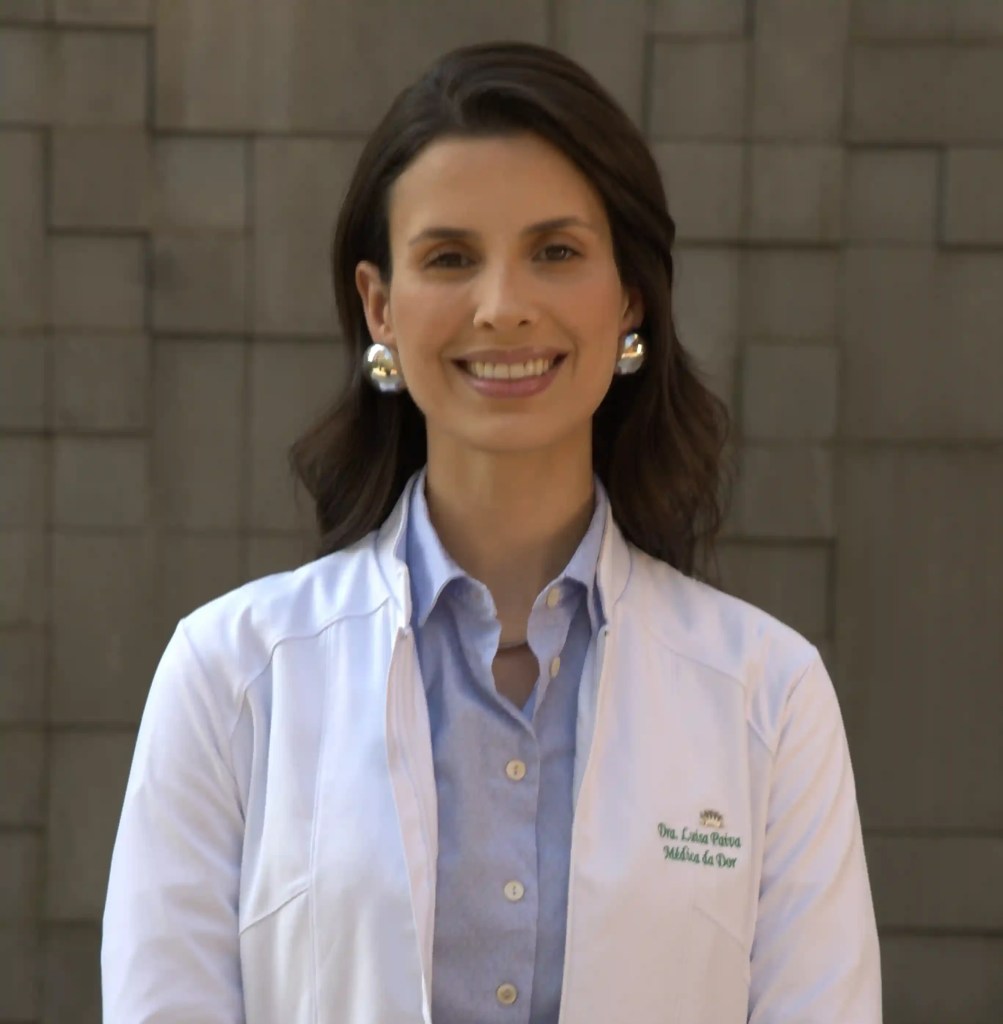 Dra. Luisa Oliveira de Paiva, médica especialista em Dor, vestindo jaleco branco e sorrindo para a câmera.