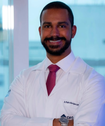 Dr. Pedro Cunha, médico neurologista, sorrindo e usando jaleco branco com crachá do Cetrus.