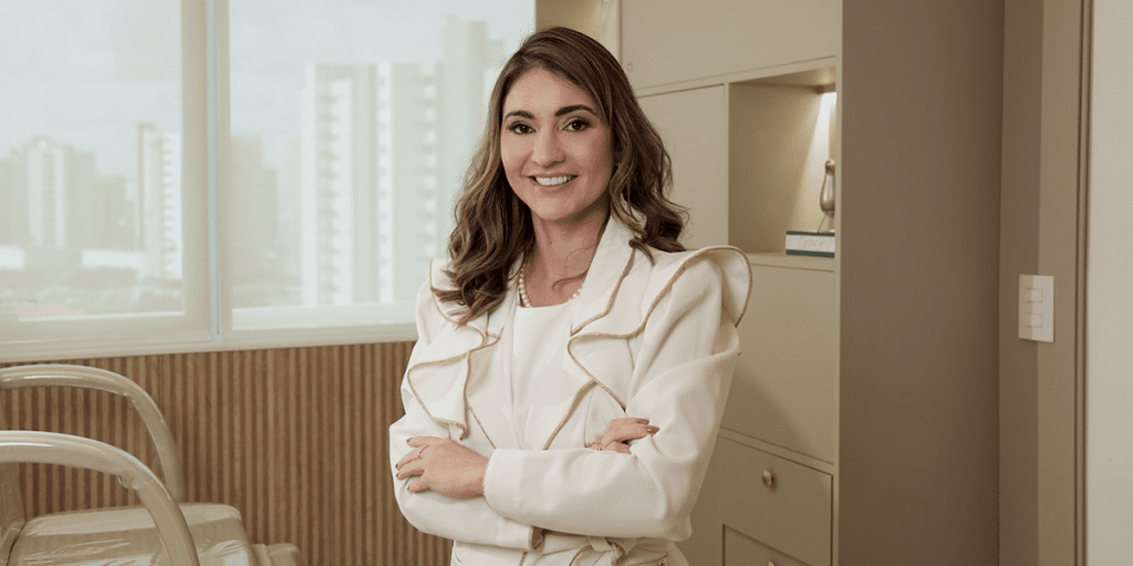 Dra. Thâmara Morita, coordenadora do Fellowship em Cosmiatria, sorrindo em fundo neutro.