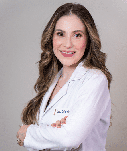 Dra. Gabriella Machado, coordenadora do Fellowship em USG Ginecológica, sorrindo em fundo neutro.