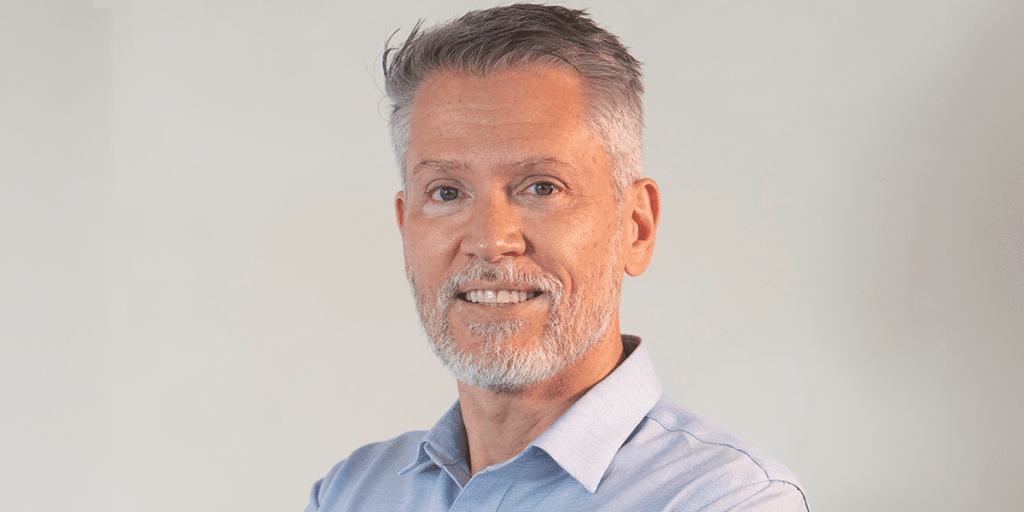 Dr. Eduardo Becker, de braços cruzados em pose confiante.